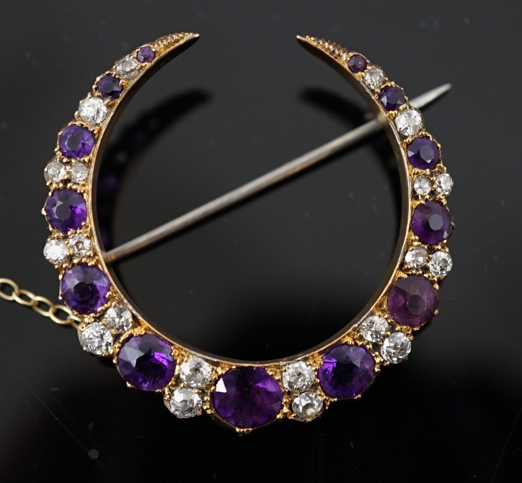 A late Victorian gold, graduated amethyst and diamond cluster set crescent brooch